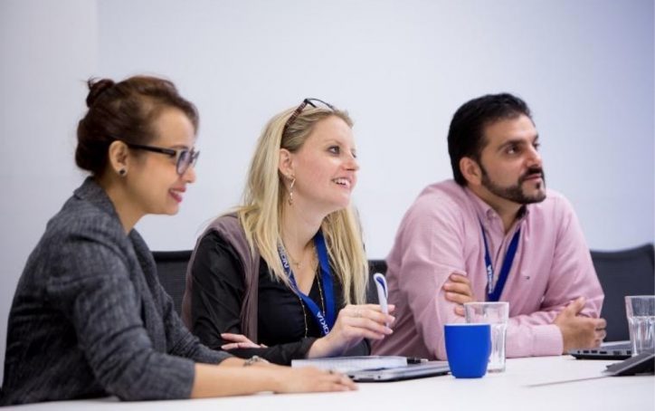 Young diverse workers sitting at conference room table