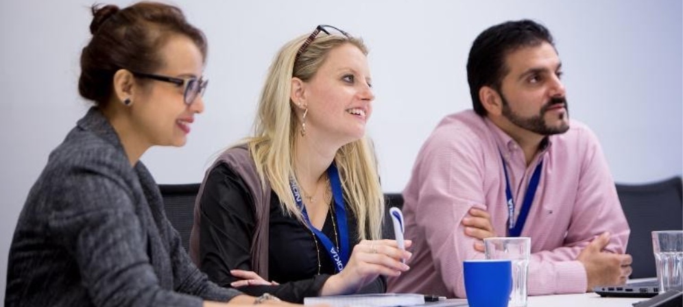 Young diverse workers sitting at conference room table